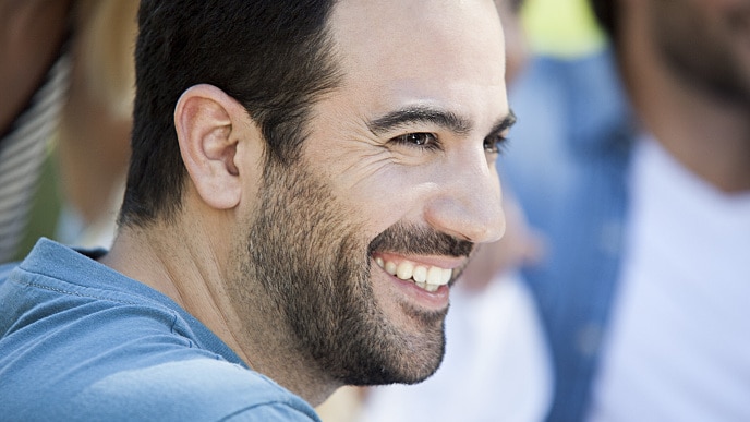 Un homme avec une barbe souriant